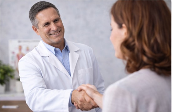 A chiropractor working with a patient on a treatment table to address shoulder discomfort