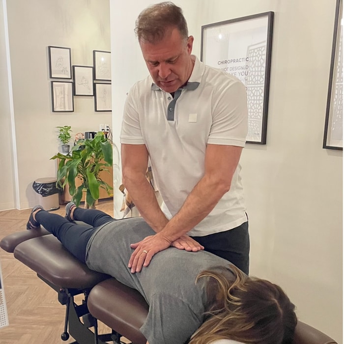 Dr. Michael Kricken providing an adjustment to a female patient to relieve sciatic pain