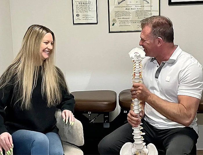 Dr. Michael Kricken consulting with a female patient about headaches & migraines with the help of a visual aid