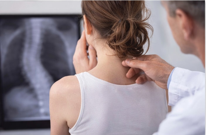 A chiropractor assessing neck mobility and alignment with a patient during a chiropractic visit